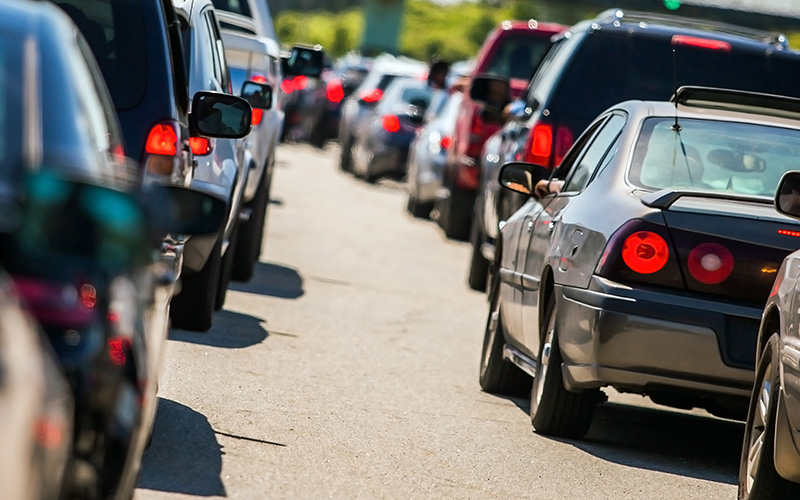 Cars on highway in bumper to bumper traffic.