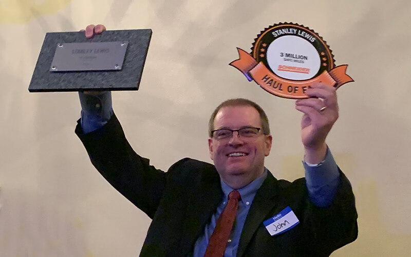 Truck driver shows Haul of Fame plaque from truck driver rewards and driver loyalty program