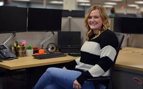 Kelsey sits at her desk in Schneider's recruiting offices.