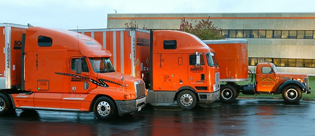 Three Schneider trucks from different eras line up at Schneider's Green Bay headquarters