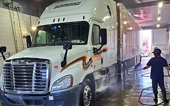 Truck wash employee shows how to wash a semi truck at a truck wash facility.