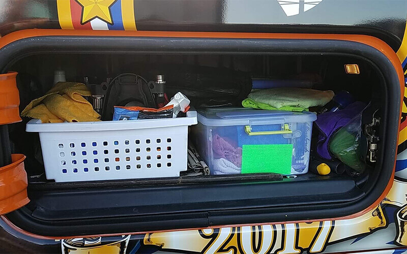 A truck storage compartment stocked with various truck driver essentials.
