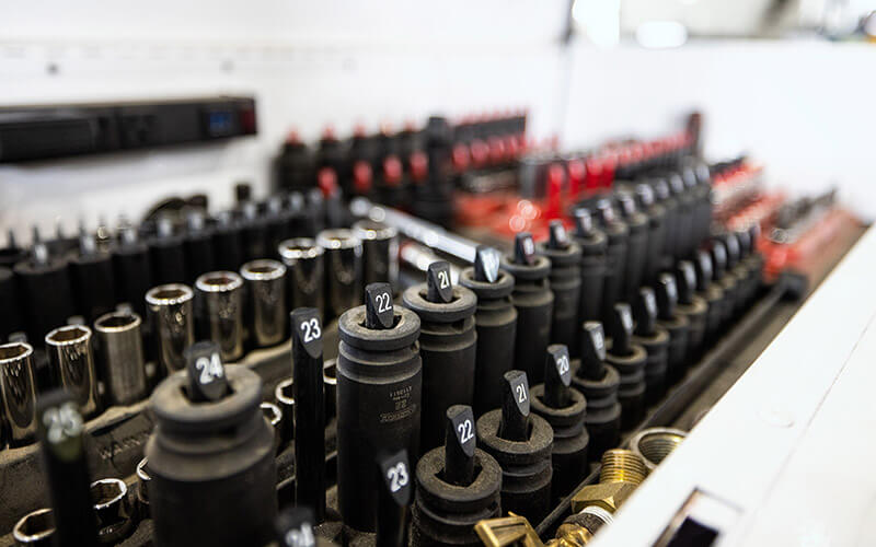A large set of drive sockets and adapters of various sizes lined up in one of Schneider's diesel shops