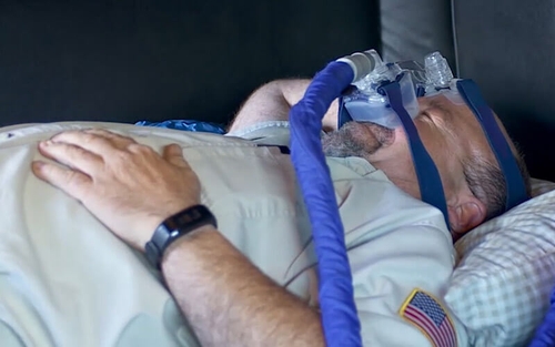 Truck driver using a CPAP machine while sleeping in their truck.