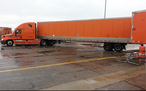 A Schneider driver demonstrates how to back a trailer at a company facility.