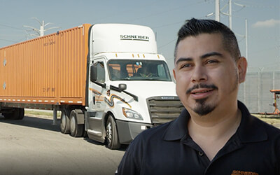 Male truck driver stands in front of Schneider Intermodal Truck