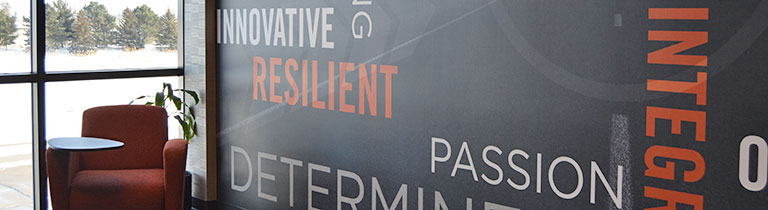 A wall at Schneider's headquarters displays a collage of impactful words including innovative, resilient and passion