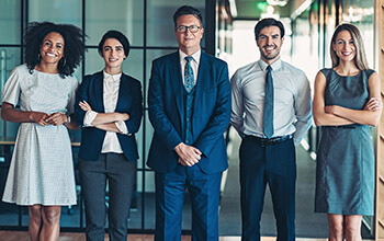 A group of individuals, dressed in business attire, stand next to one another.