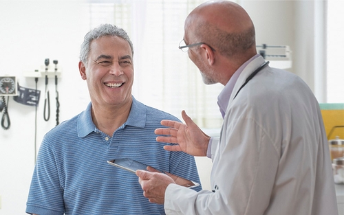 A patient discussing with a medical examiner in a well-lit office.