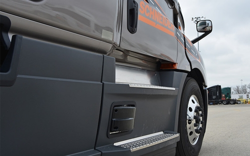 The passenger side of a Schneider semi-truck cab, showing the radar used for the Side Guard Assist system.