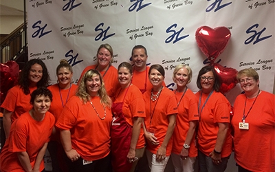 A group of associates represent Schneider by wearing "Omaha orange" shirts while volunteering at the Back to School Store event.
