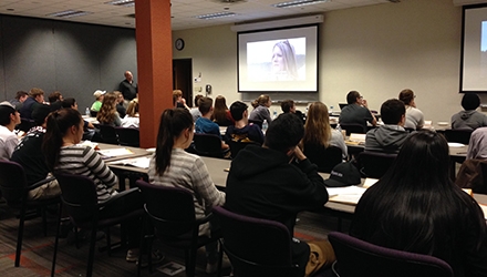 More than 40 teens watch an informational video on distracted driving in a Schneider training room.
