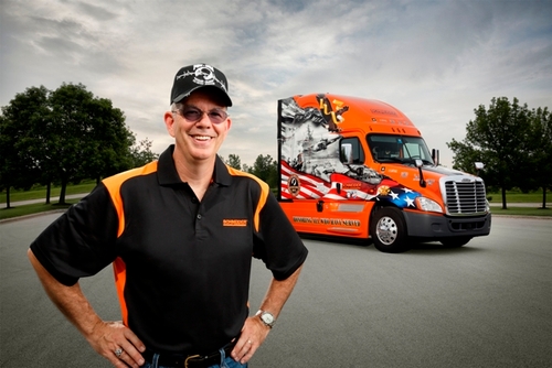 2015 Schneider Ride of Pride driver Jay Hull poses in front of his Ride of Pride truck while wearing a POW/MIA baseball cap