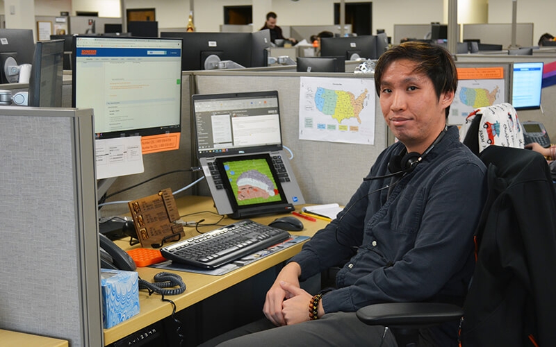 Hoi-An Thai sits at his desk.