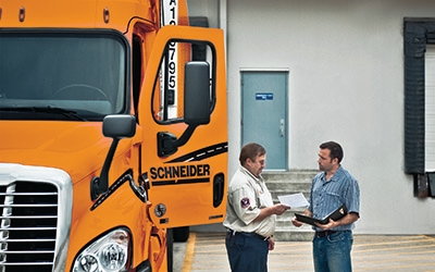 A Schneider driver speaks with a customer outside of the loading docks.