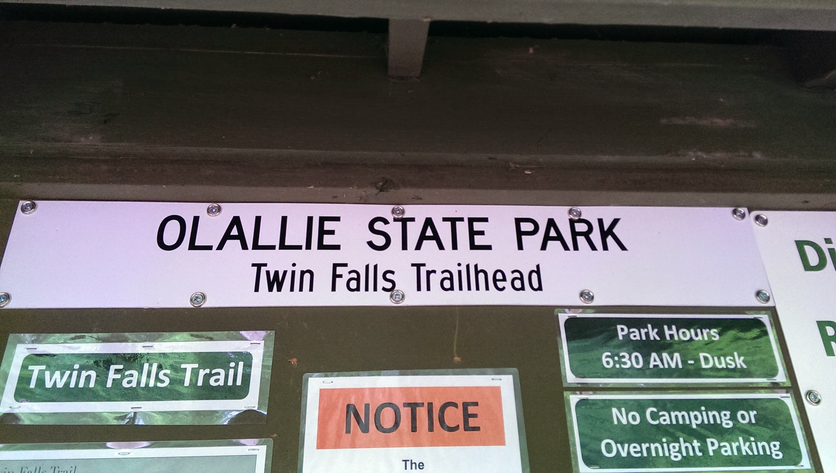 An information board at the Olallie State Park Twin Falls Trailhead. The sign states park hours are from 6 am to dusk and prohibits camping and overnight parking.