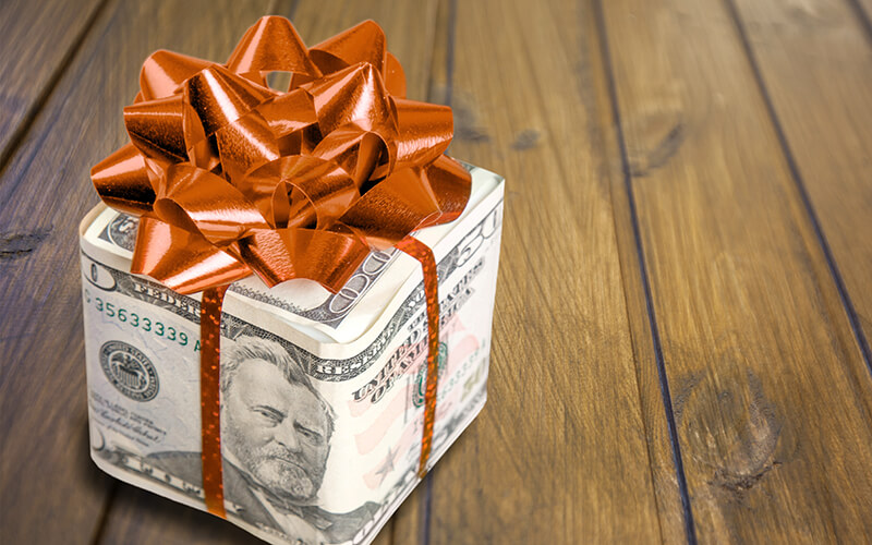 A gift wrapped in $50 bills waits to be opened.