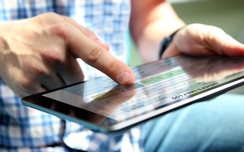 A truck driver filling out their daily log using an Electronic Logging Device.