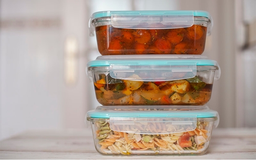 A stack of three Tupperware containers with pre-portioned meals and snacks inside.