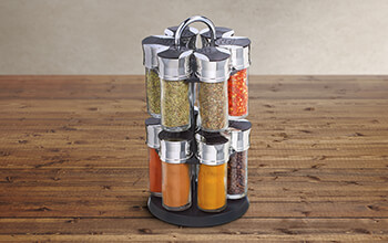A variety of spice containers are stored on a small and portable spice rack.
