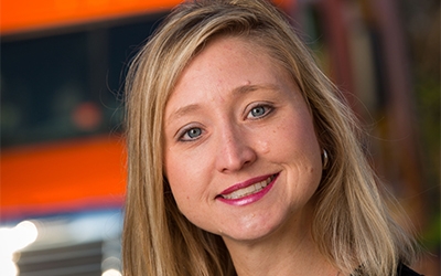 Becky Collar poses in front of a display at Schneider's corporate office.