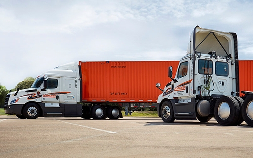 A Schneider day cab parked in front of a Schneider intermodal truck.