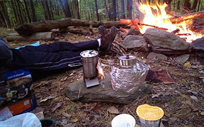 Schneider driver associate Carl resting by the fire at a campsite