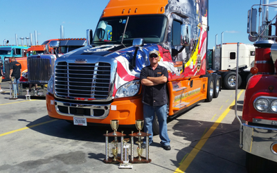 2016 Ride of Pride drive John Ritscher poses in a busy truck lot with his Ride of Pride truck and awards