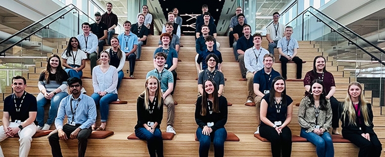 A group of Schneider interns pose together on the steps of The Grove, Schneider's technology building in Green Bay, Wisconsin.