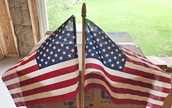 The small American Flags that Bob had attached to his truck during his trip to Ground Zero are displayed back to back in his garage.