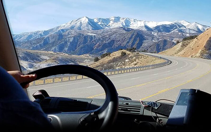 A truck driver heads down a mountain road.