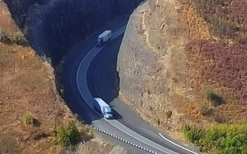 Mountain road aerial shot with 2 tractor trailers