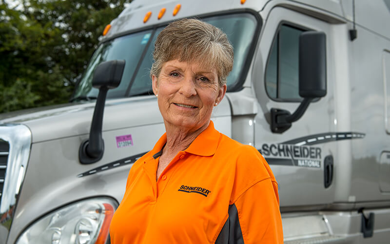 Schneider Over-the-Road driver Fay Dunn stands in front of her truck.