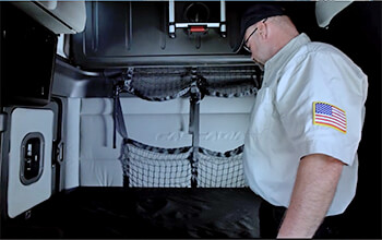 Driving Instructor Brett shows whats all included in the back bunk area of a semi-truck. This semi-truck bunk area includes a bunk bed and two windows.