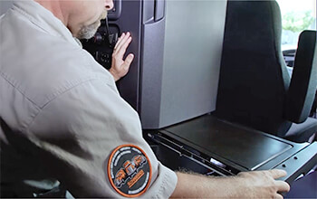 Driving Instructor Brett pulls out the work desk behind the driver's seat and below the closet inside of a semi-truck.