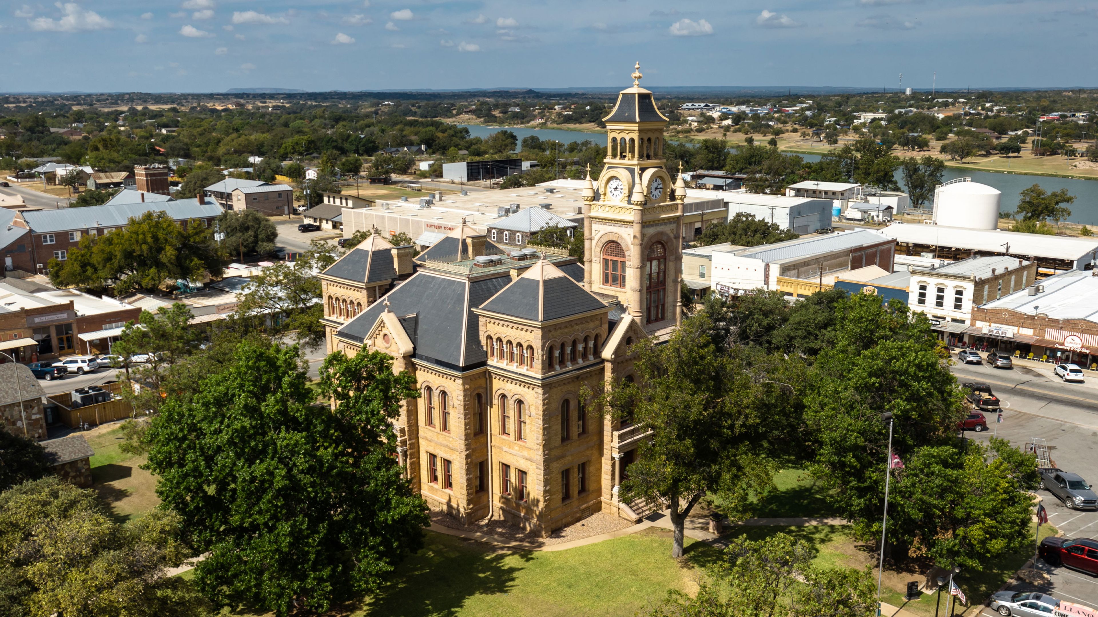 Aerial view of a small town with a prominent historic building, surrounding streets, houses and trees