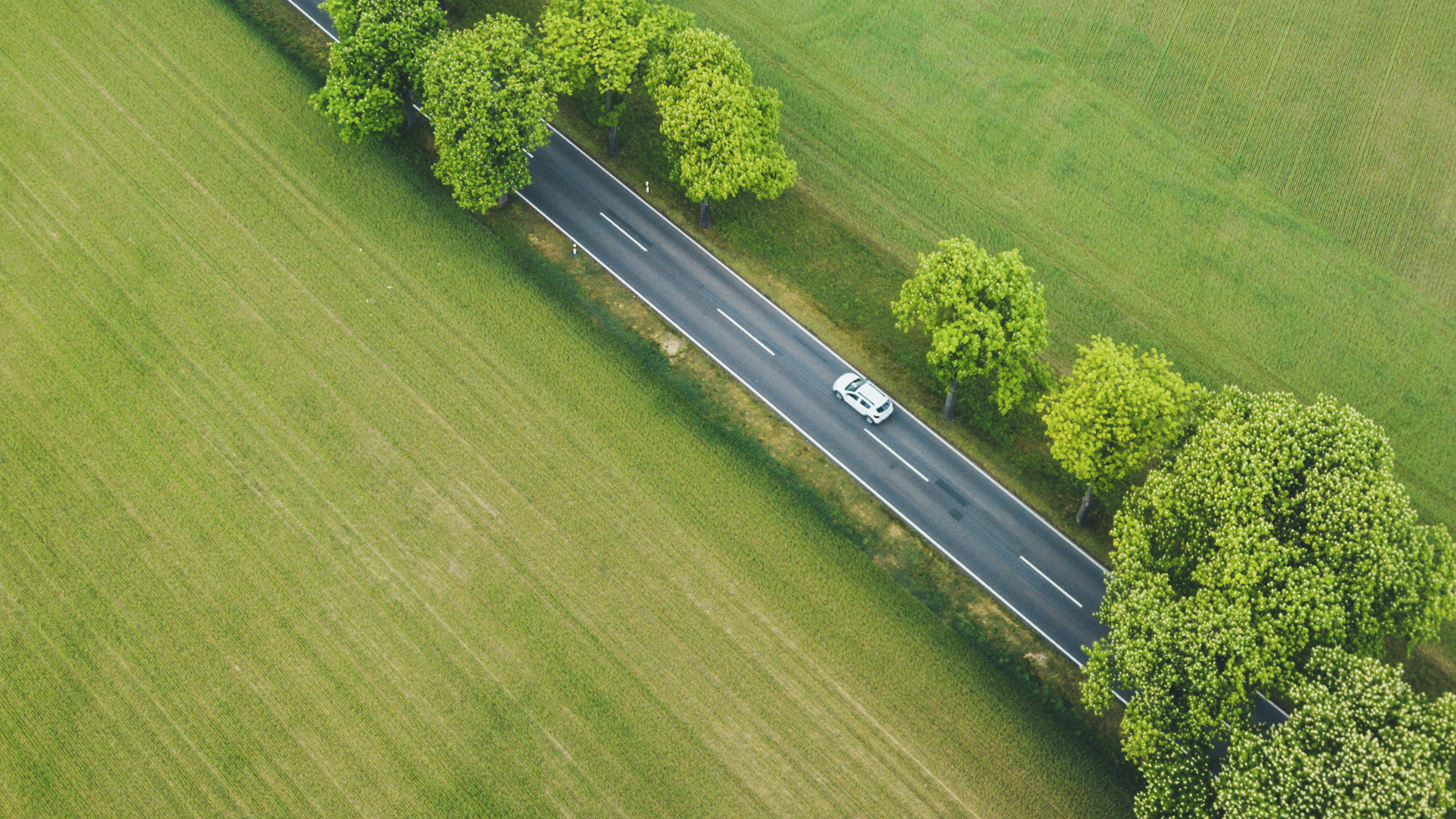 Aerial view of a vehicle on a rural road representing EV adoption in rural areas