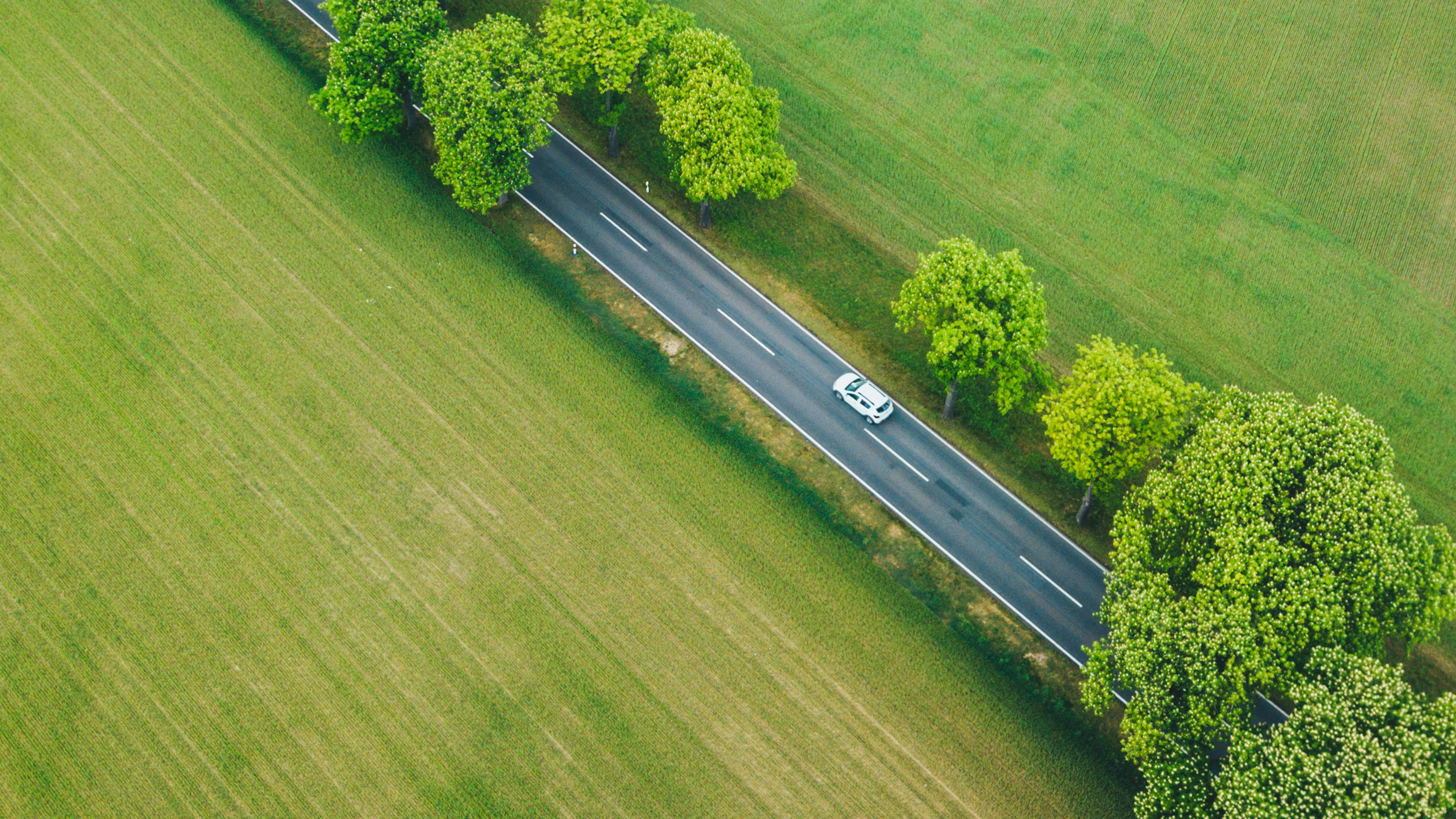 Aerial view of a vehicle on a rural road representing EV adoption in rural areas