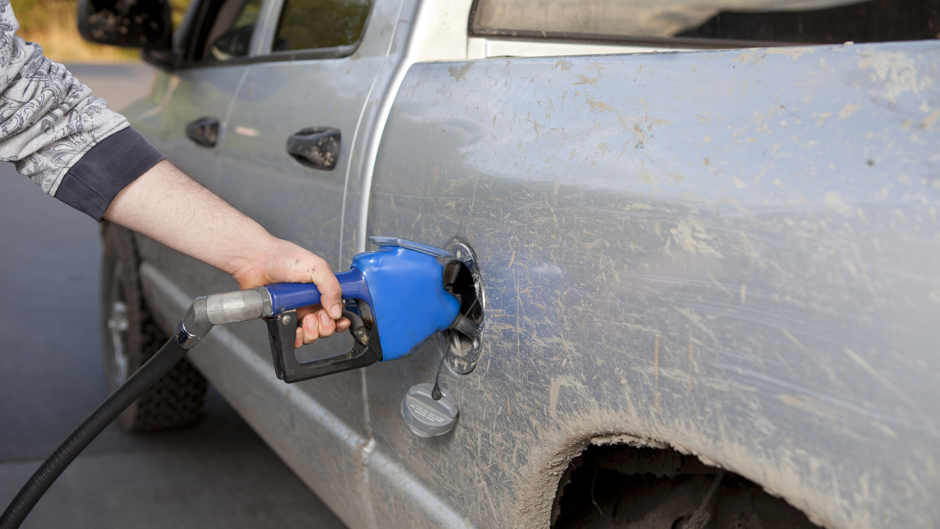 a farmer fuels up his pickup truck
