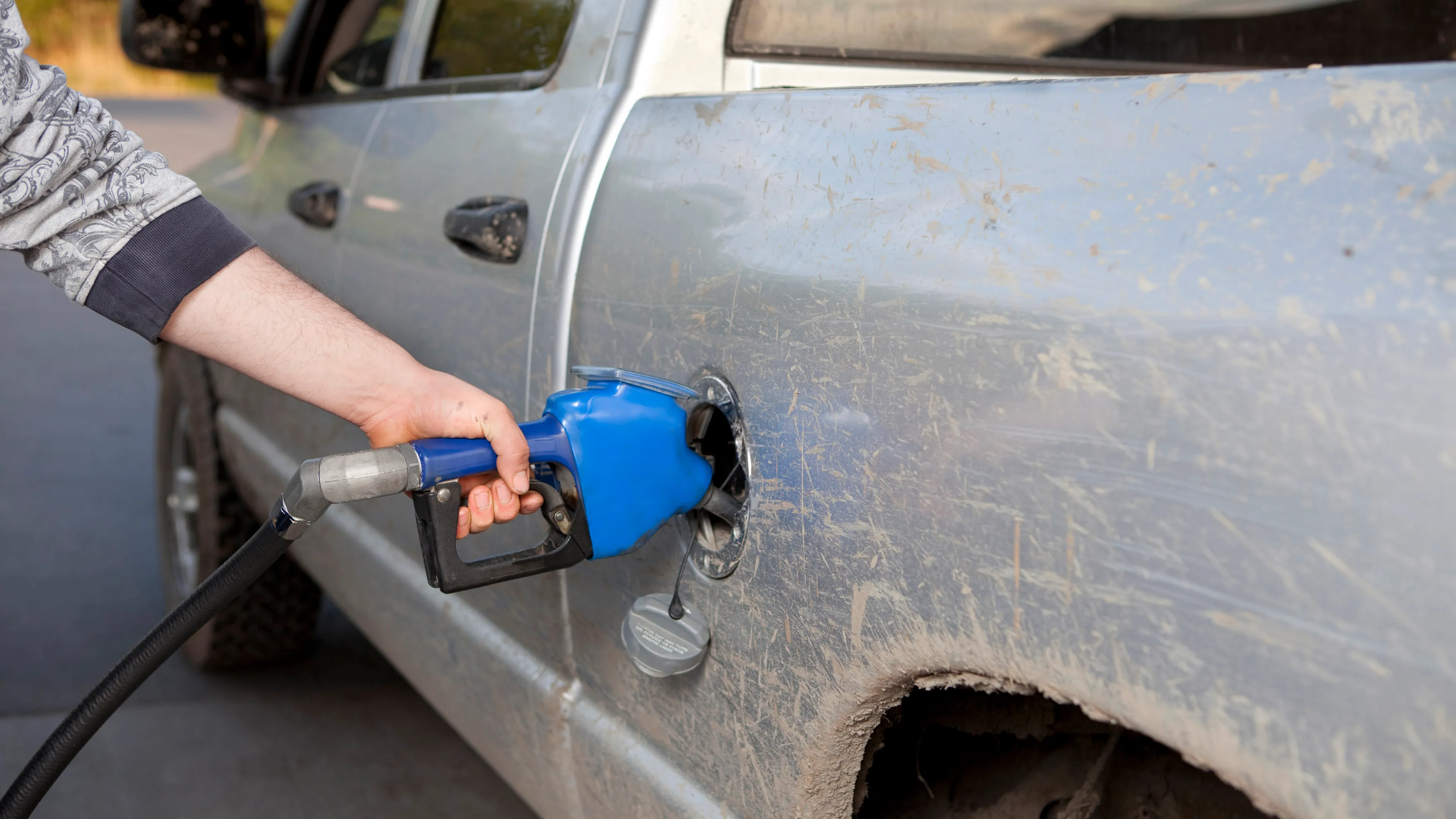 a farmer fuels up his pickup truck