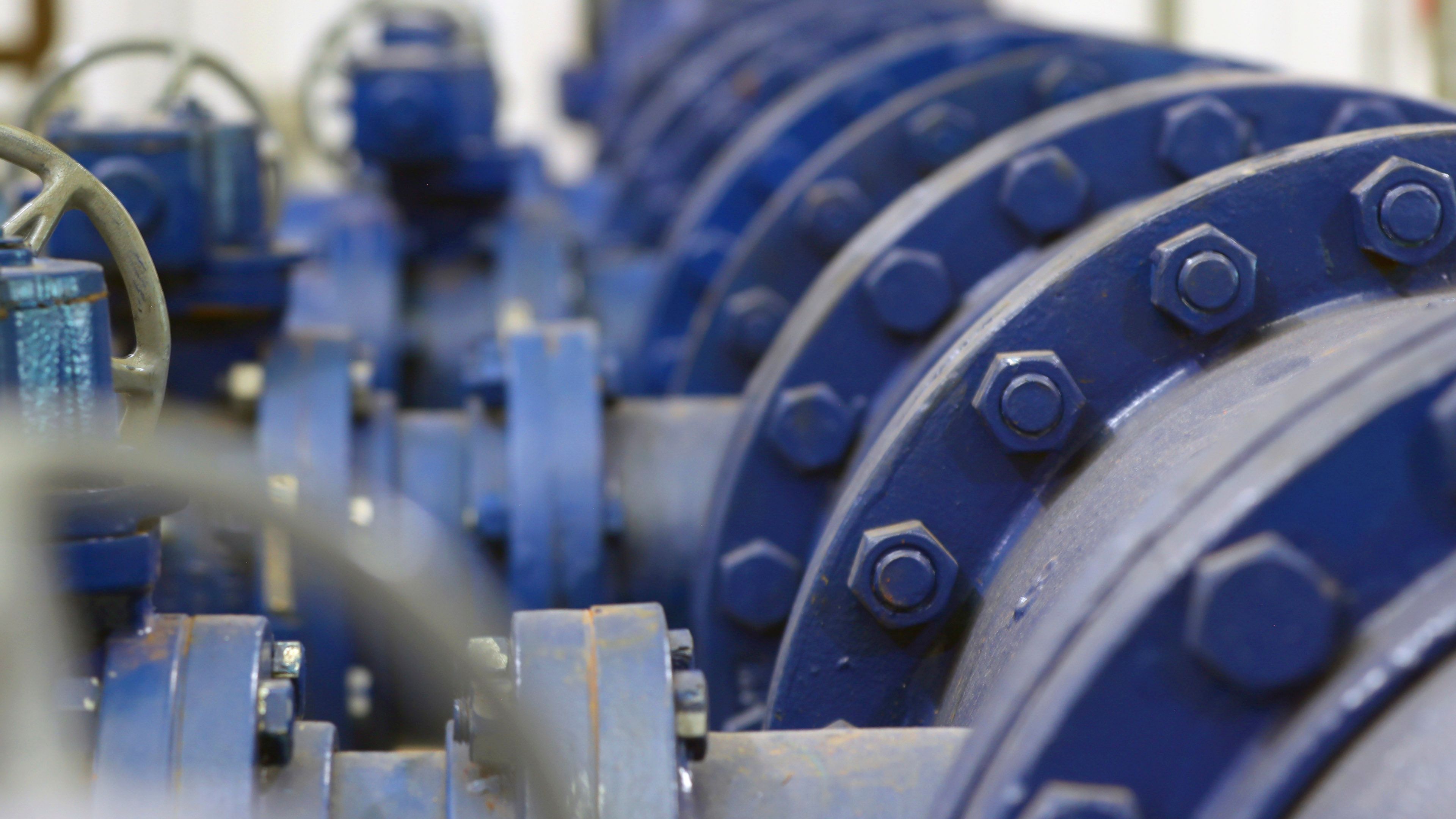 Close view of industrial equipment with metal piping, bolts and mechanical components used in water or utility infrastructure systems