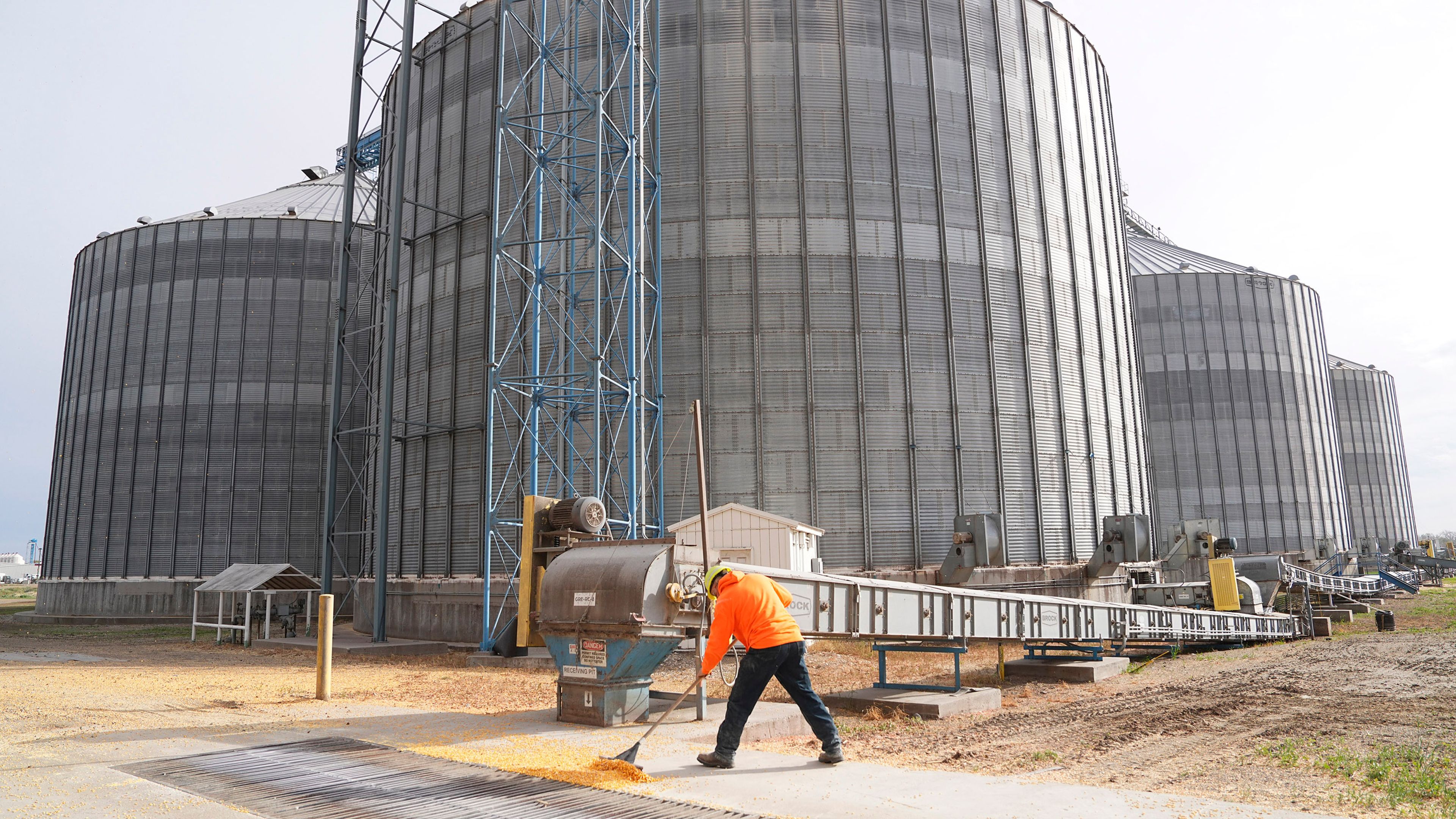 Industrial grain storage facility with cylindrical silos and a worker on site