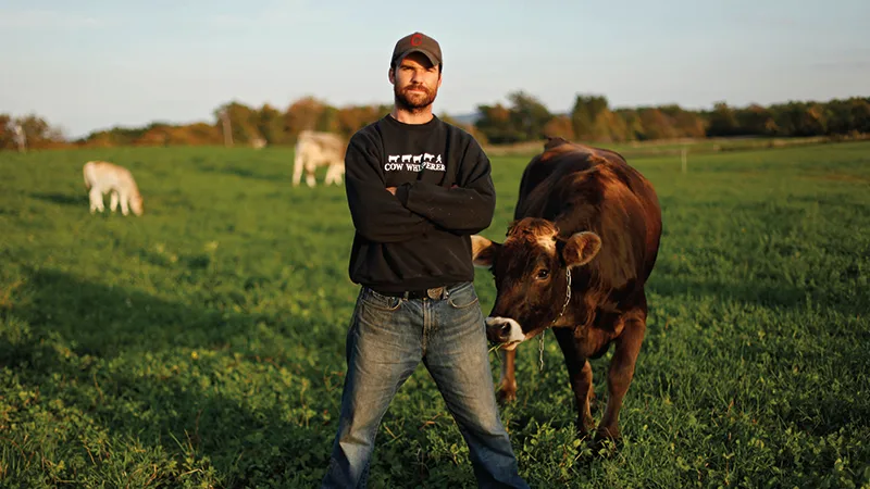 Farmer in a field next to a cow