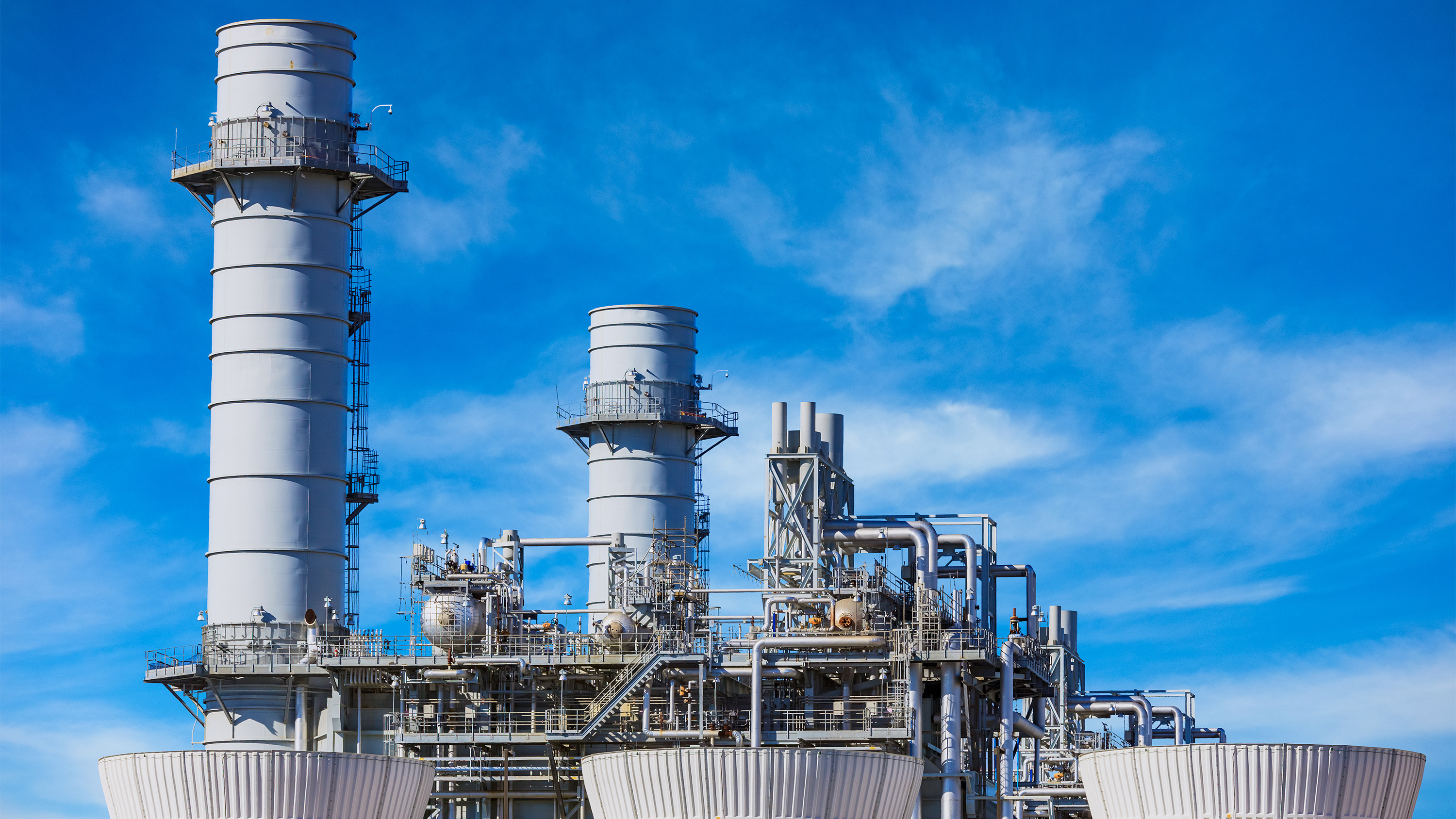 Natural gas-fired turbine power plant in front of blue sky