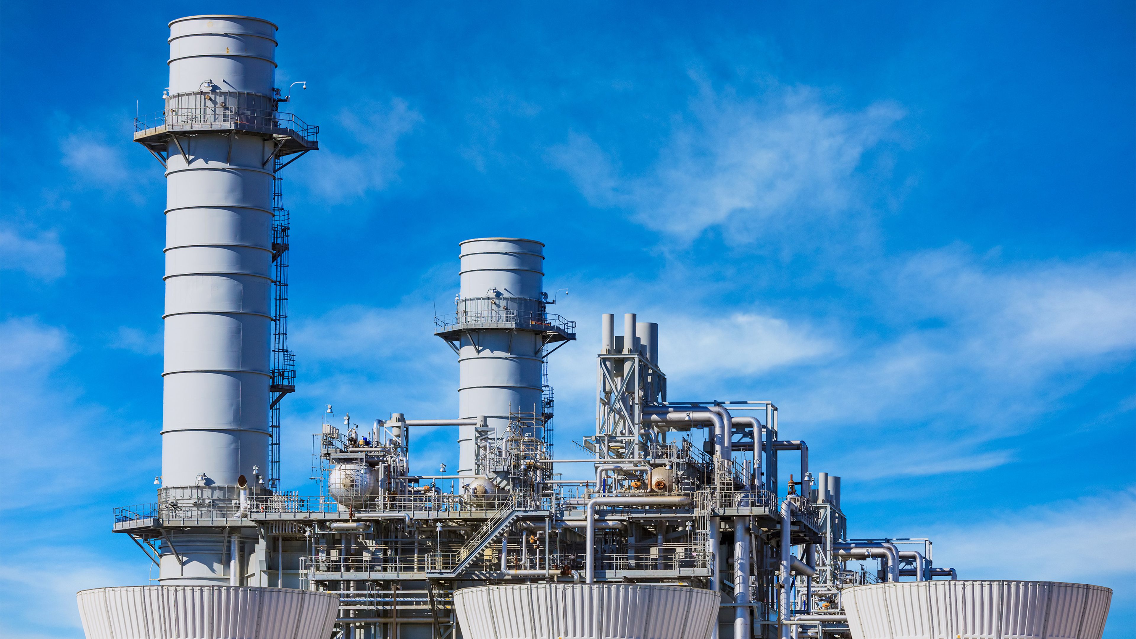 Natural gas-fired turbine power plant in front of blue sky
