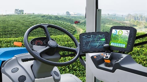 Inside farm machinery cab, with steering wheel and digital displays