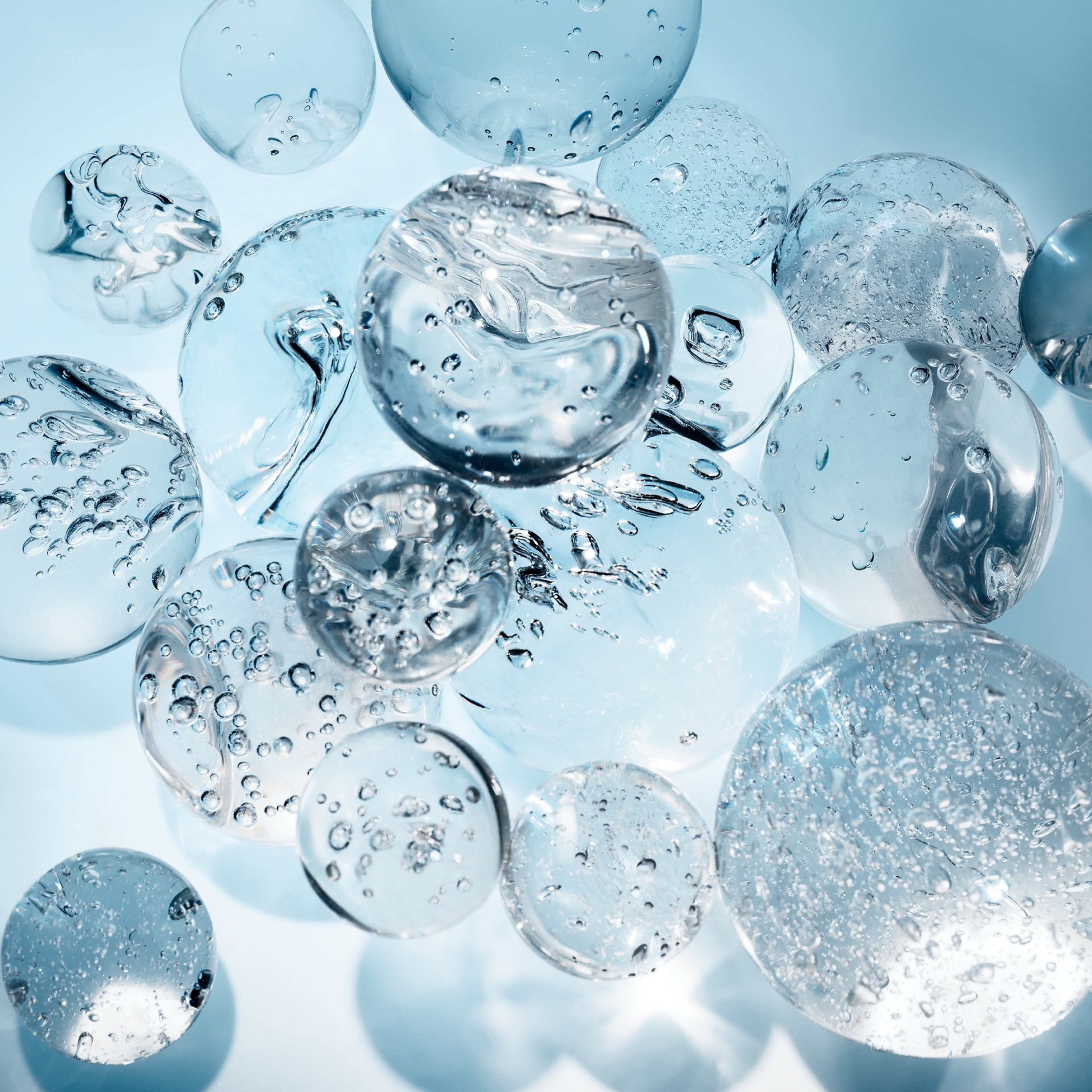 Clear bubbles and droplets with reflections on a blue background