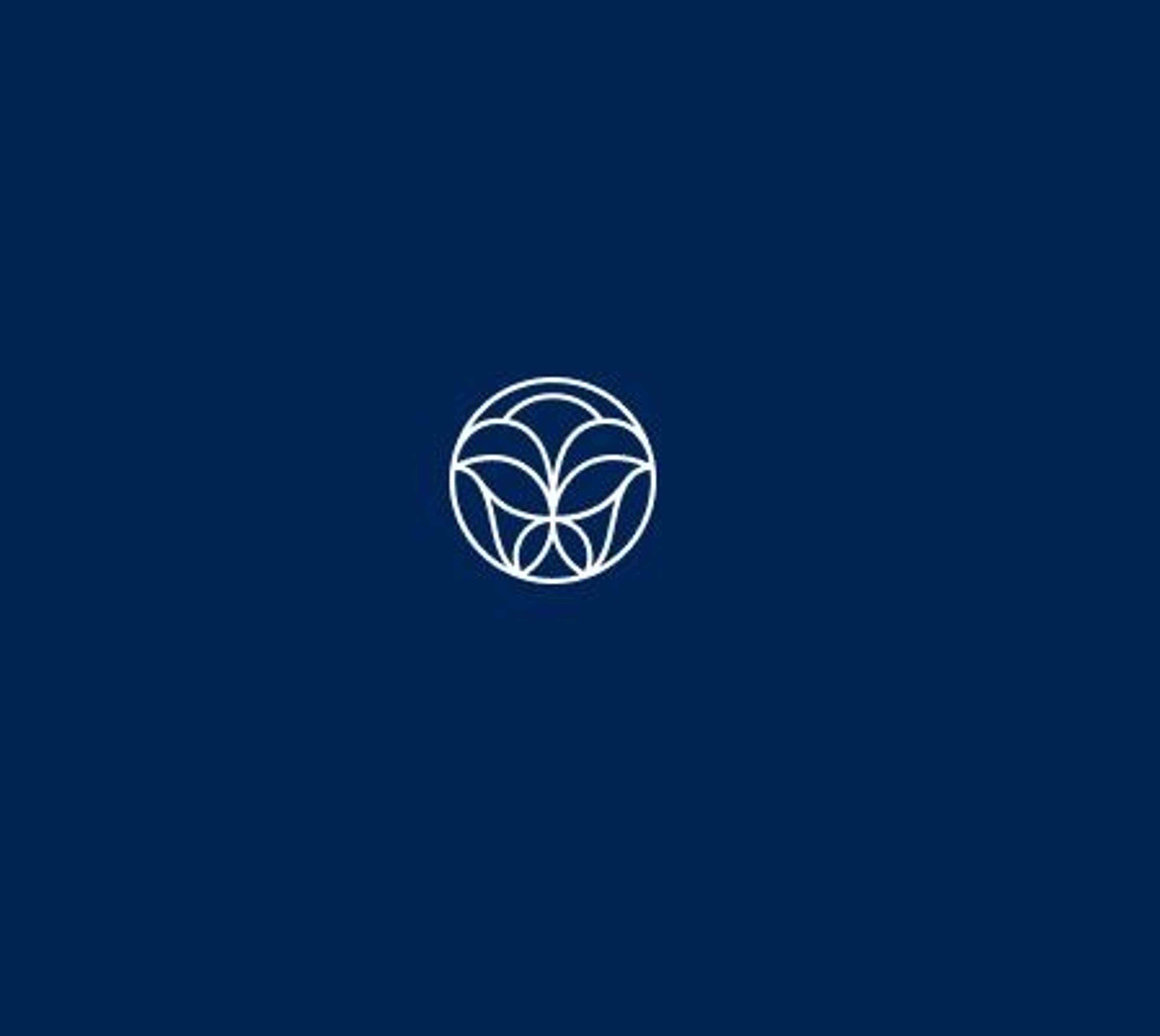 A white circular emblem with leafy design on a dark blue background