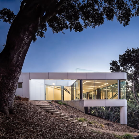The exterior back of a home surrounded with floor-to-ceiling windows