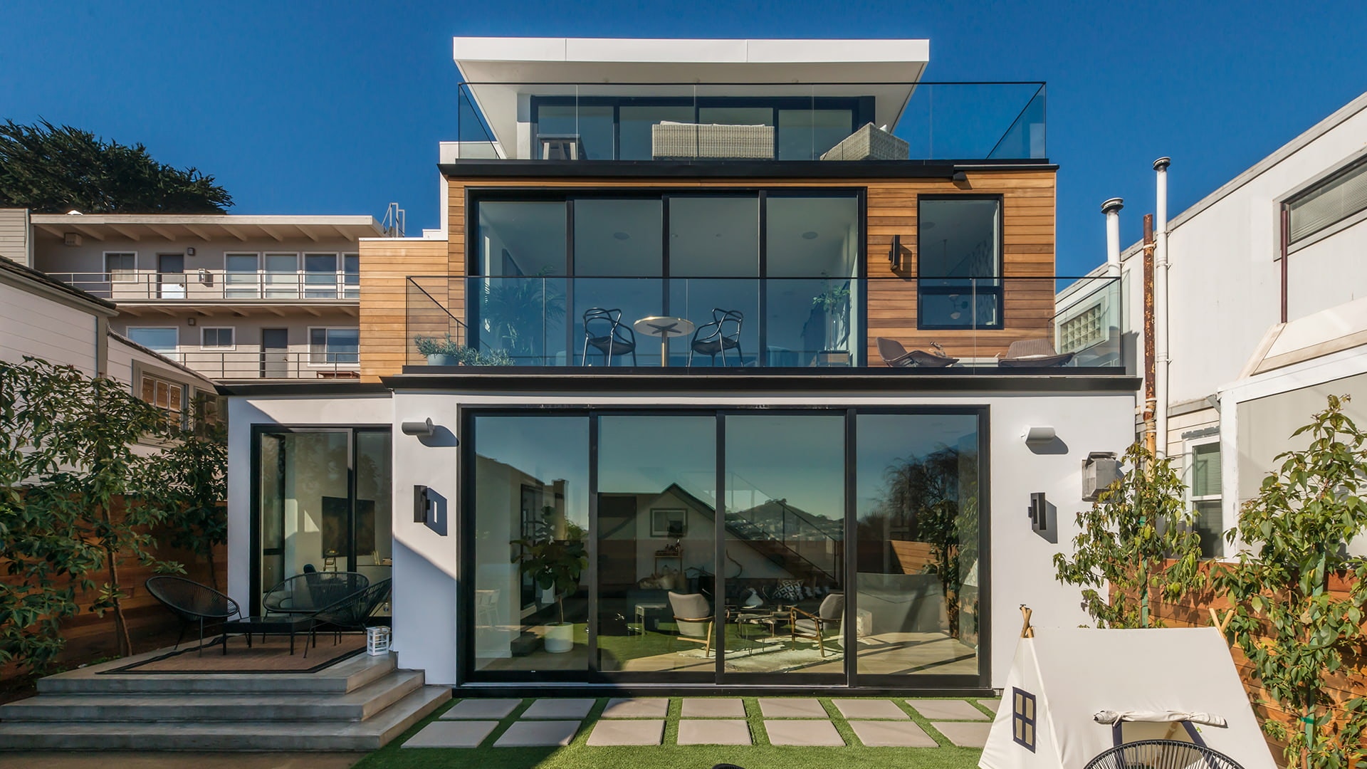 A three-story home, each floor with a four-panel multi-slide door
